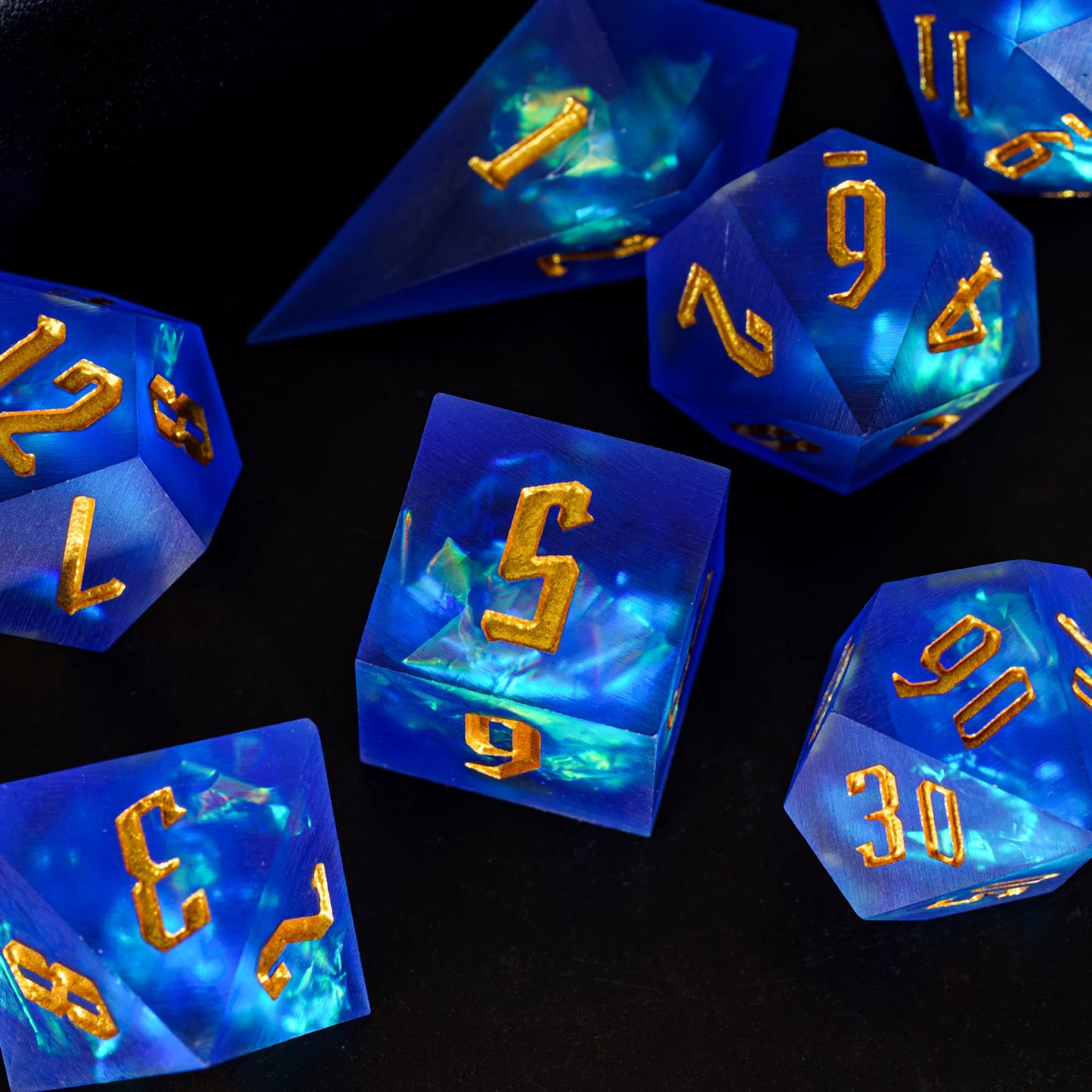Azure Abyss Sharp Edge Dice Set laid out on tabletop with gold inking for DnD & DnD 5e