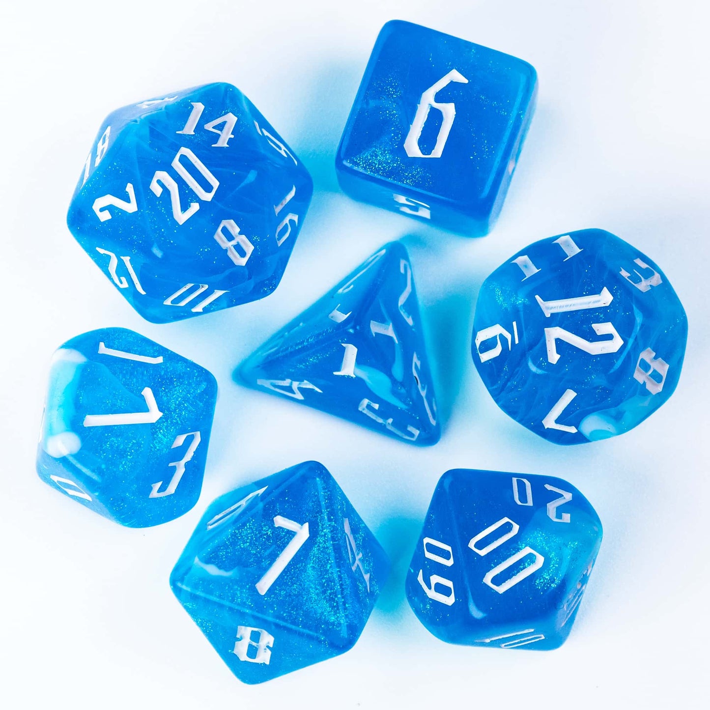 Flat lay of Blue Ice Dice Set 7 piece resin polyhedral dice with white numbers for DnD