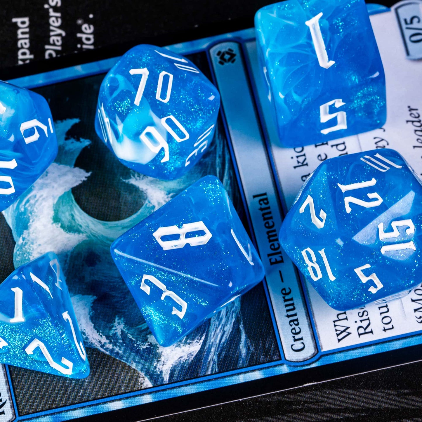 Blue Ice Dice Set resin polyhedral dice with white numbers on trading card background for DnD