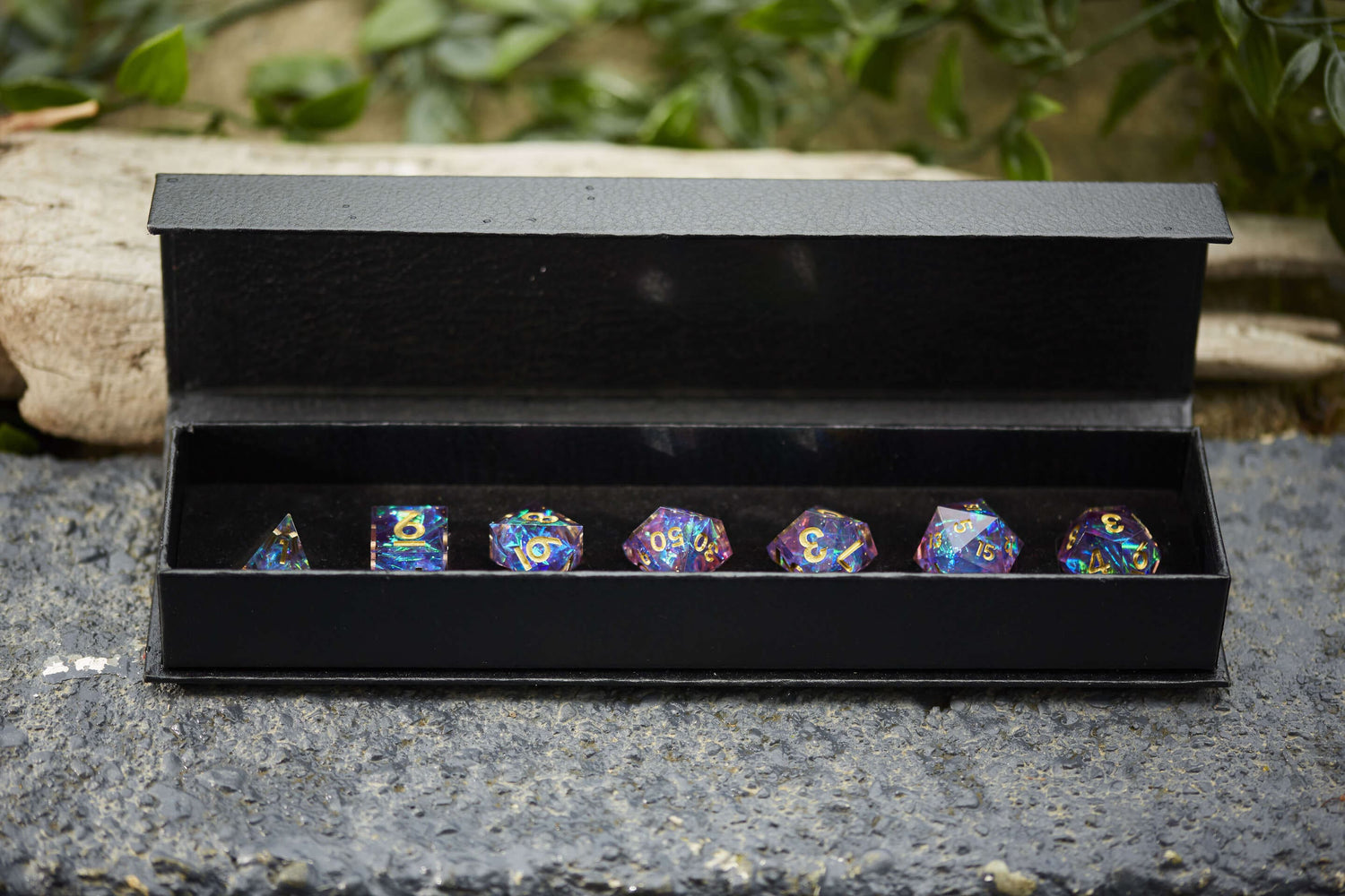 Celestial Heart sharp-edge resin dice set with holographic swirls and gold numbering, displayed in a black gift box for Dungeons & Dragons.