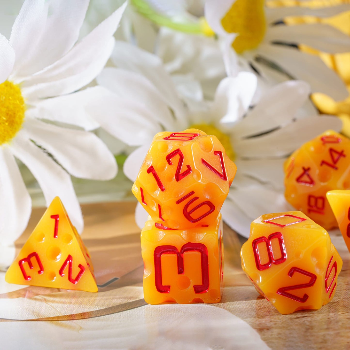 Cheese Dice Set, 7 piece yellow dice with red numbering displayed with flowers for DnD