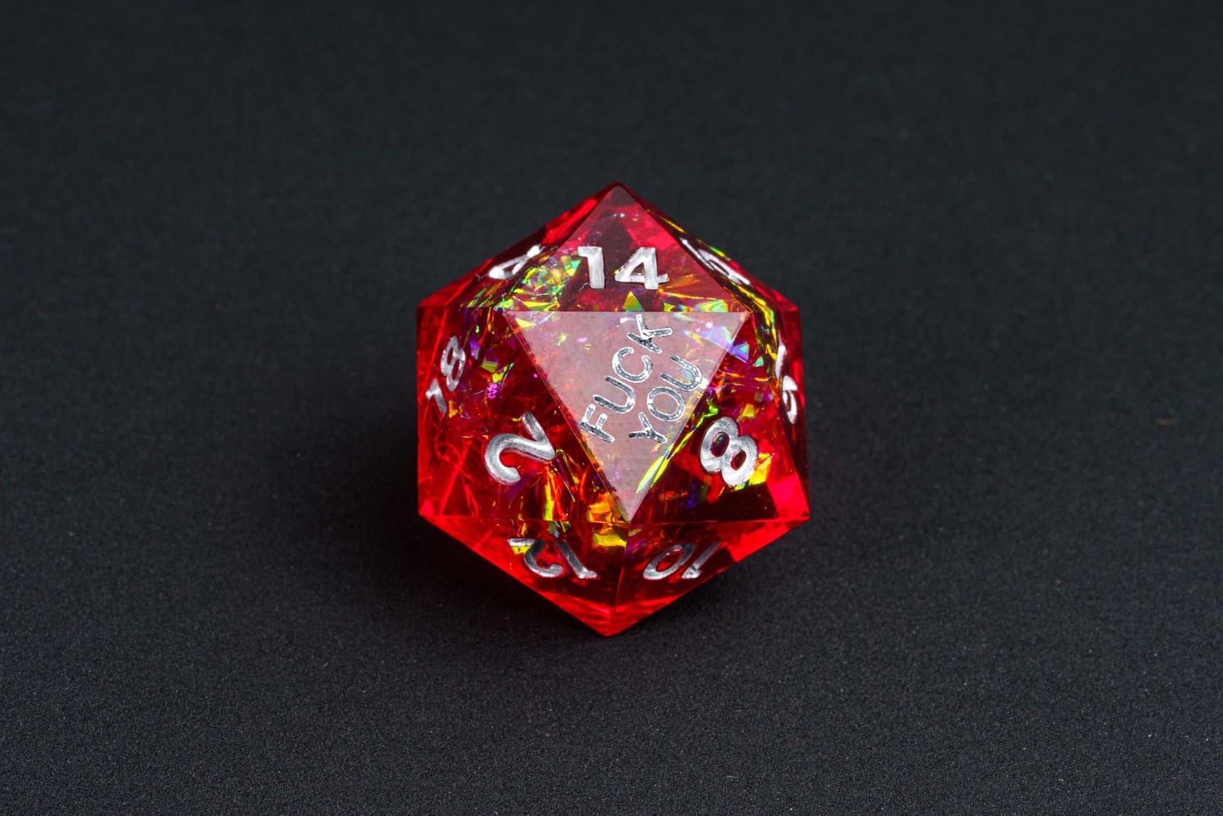 Chromatic Blood sharp-edge D20 from the Fck Me Dice Set, red resin with silver numbering and 'Fck You' lettering