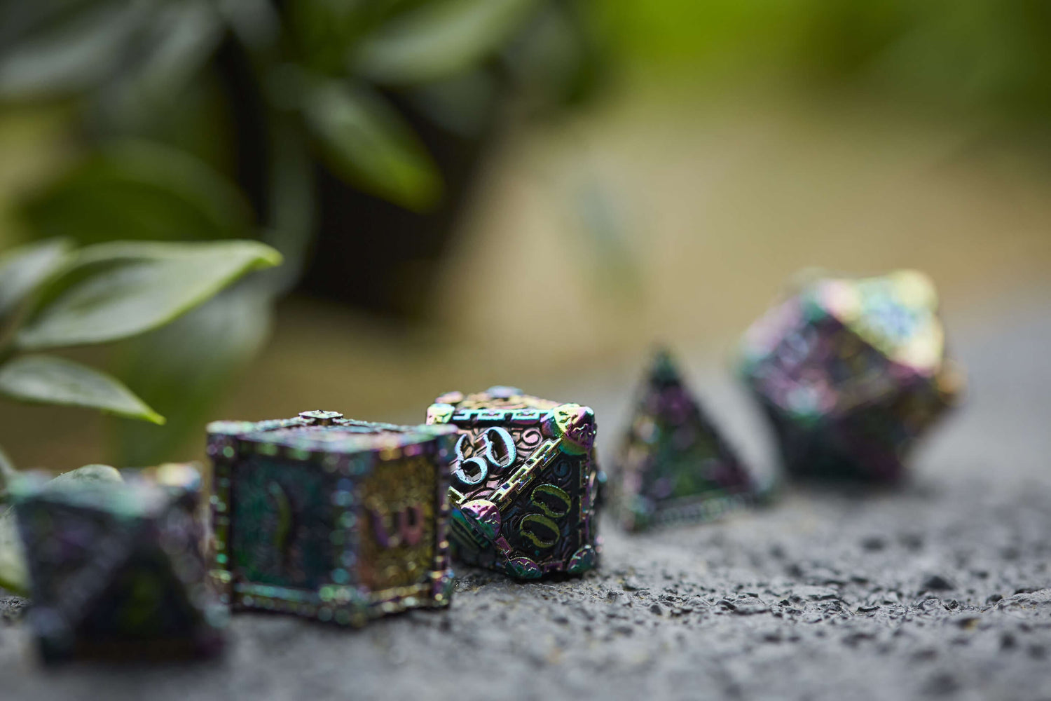 Detailed view of full iridescent metal RPG dice set outdoors, ideal for fantasy tabletop games like D&D.