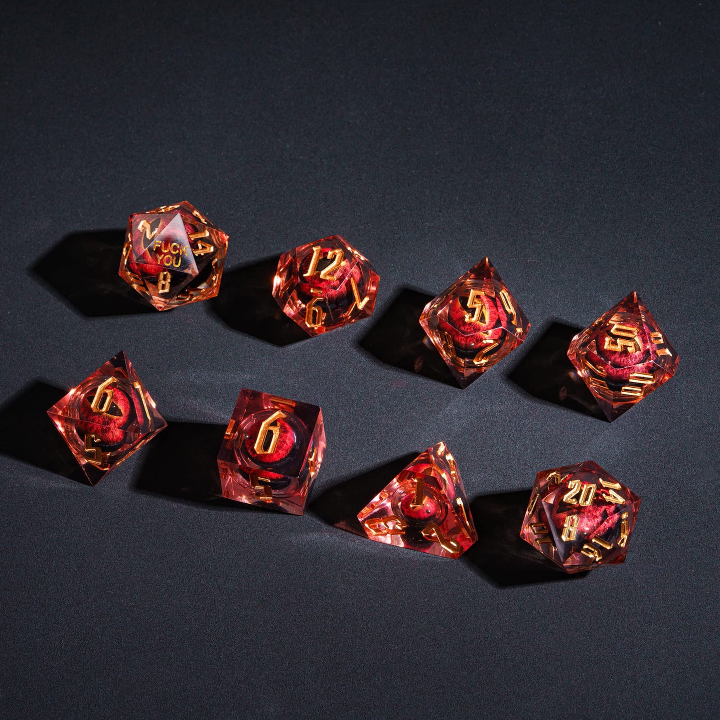 Flat lay of Dragon Eye (Red) F*ck Me Sharp Edge Dice Set, full 8-piece collection for DnD & TTRPGs