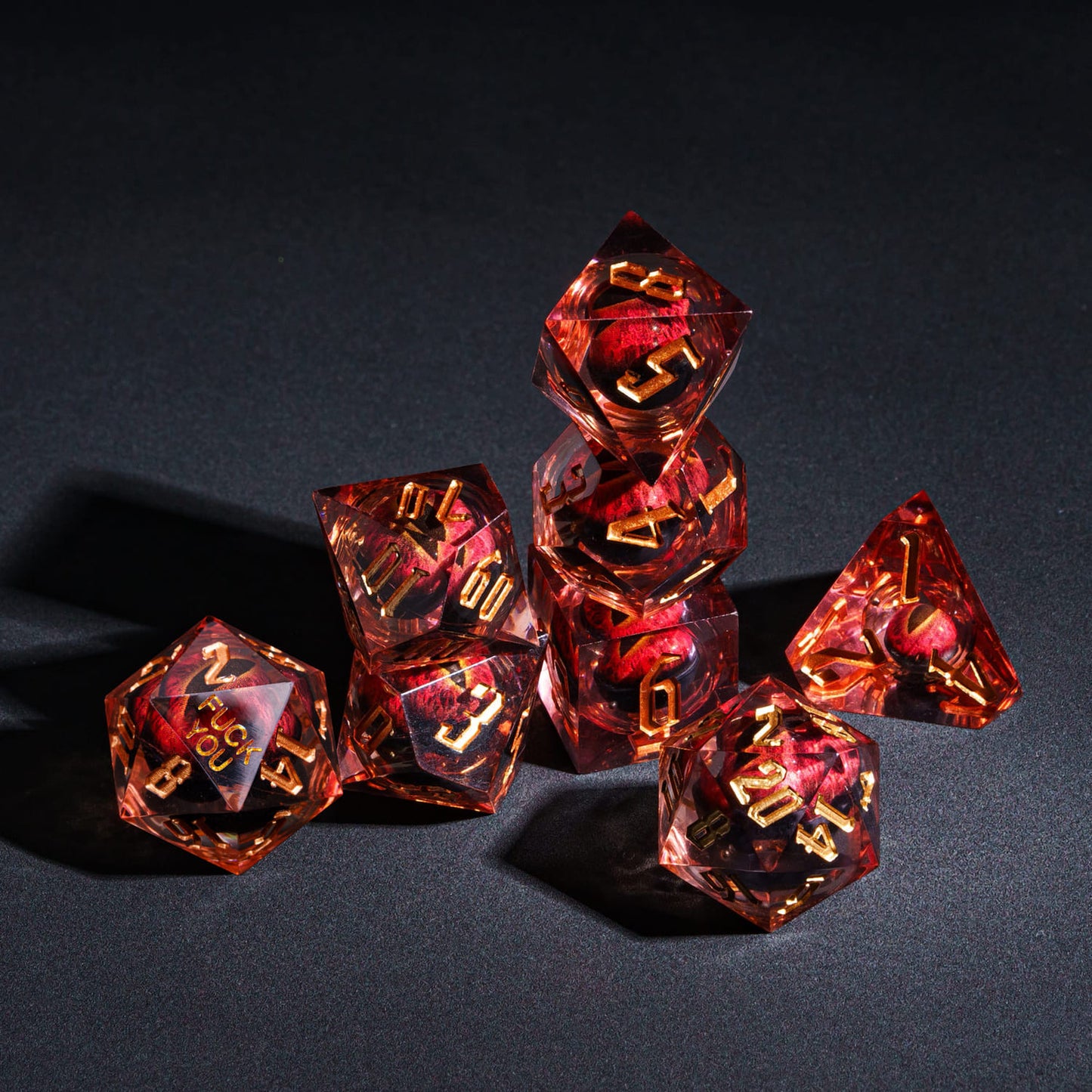 Stacked arrangement of Dragon Eye (Red) F*ck Me Sharp Edge Dice Set highlighting embedded eye and sharp edges