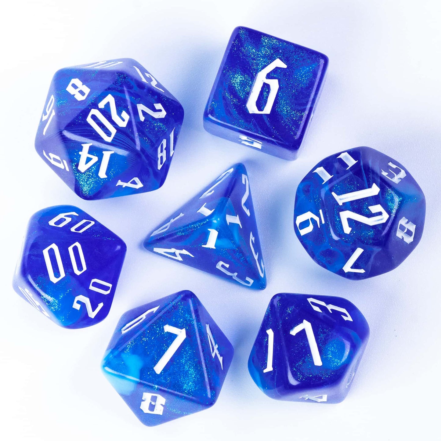 Flat lay of Glacier Blue Dice Set 7 piece resin polyhedral dice with white ink for DnD