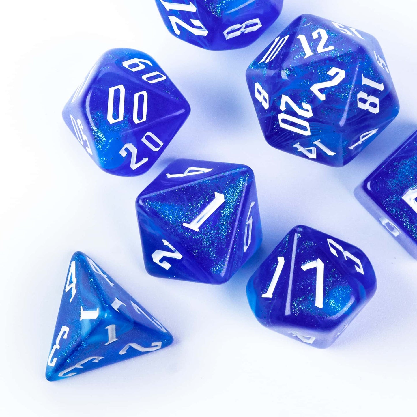 Glacier Blue Dice Set resin polyhedral dice stacked on book for DnD and tabletop roleplaying games