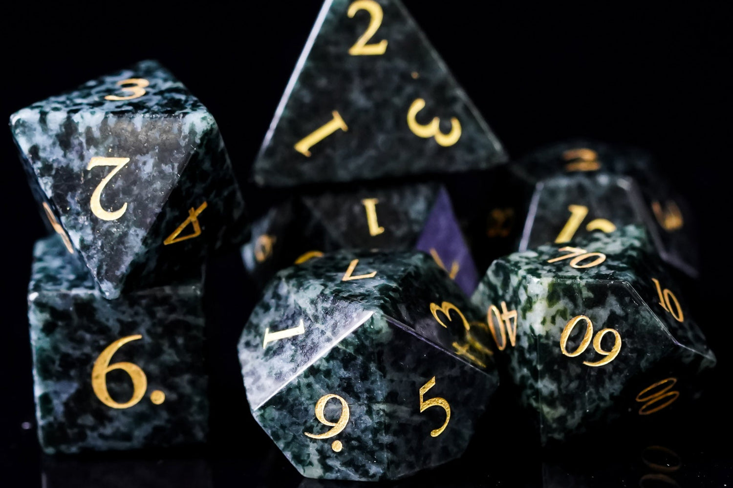 Sharp-edge green gemstone dice set with gold numbering, polished for use in Dungeons & Dragons and fantasy TTRPGs.