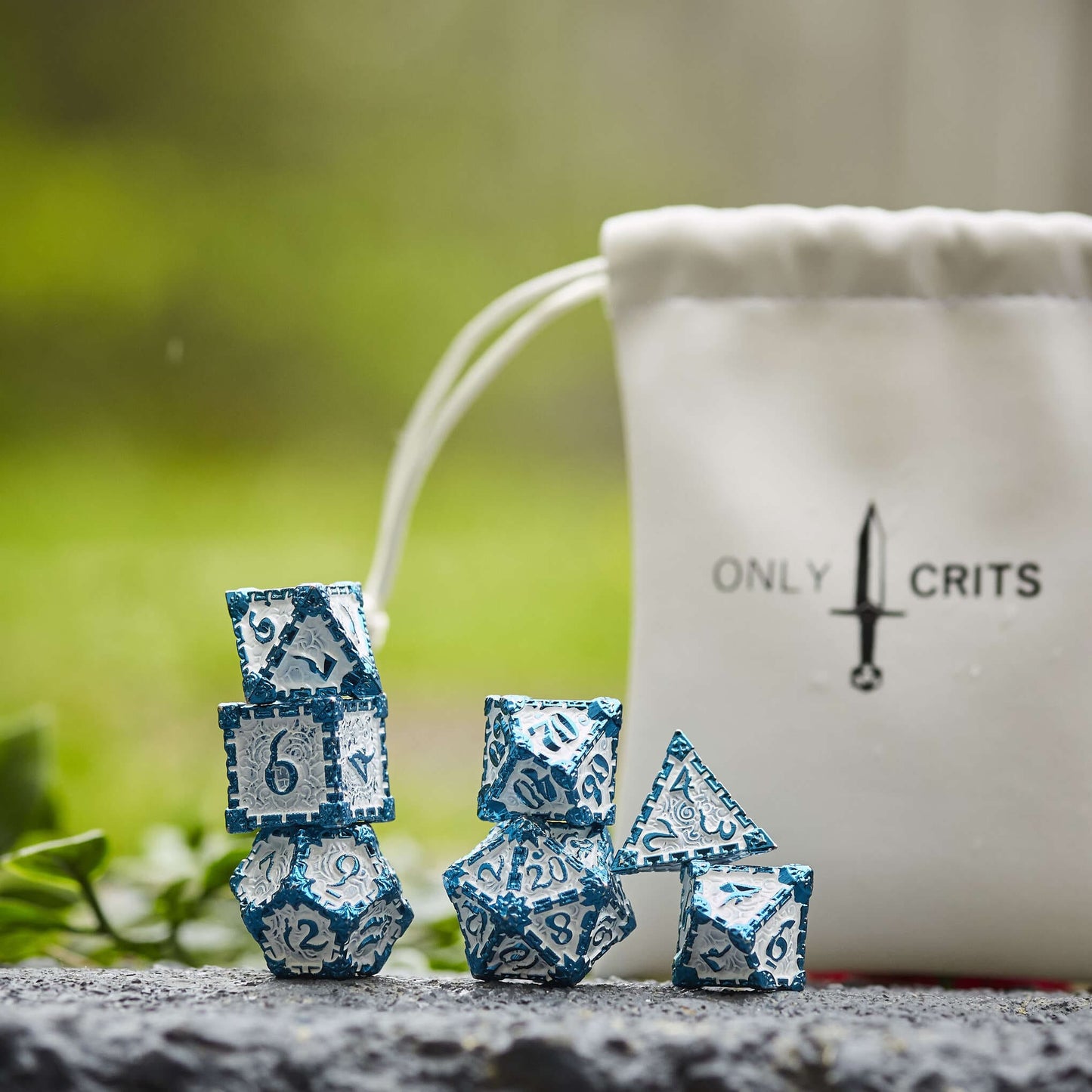 Icy Blade metal dagger dice set for DnD & TTRPG, displayed with bag outdoors