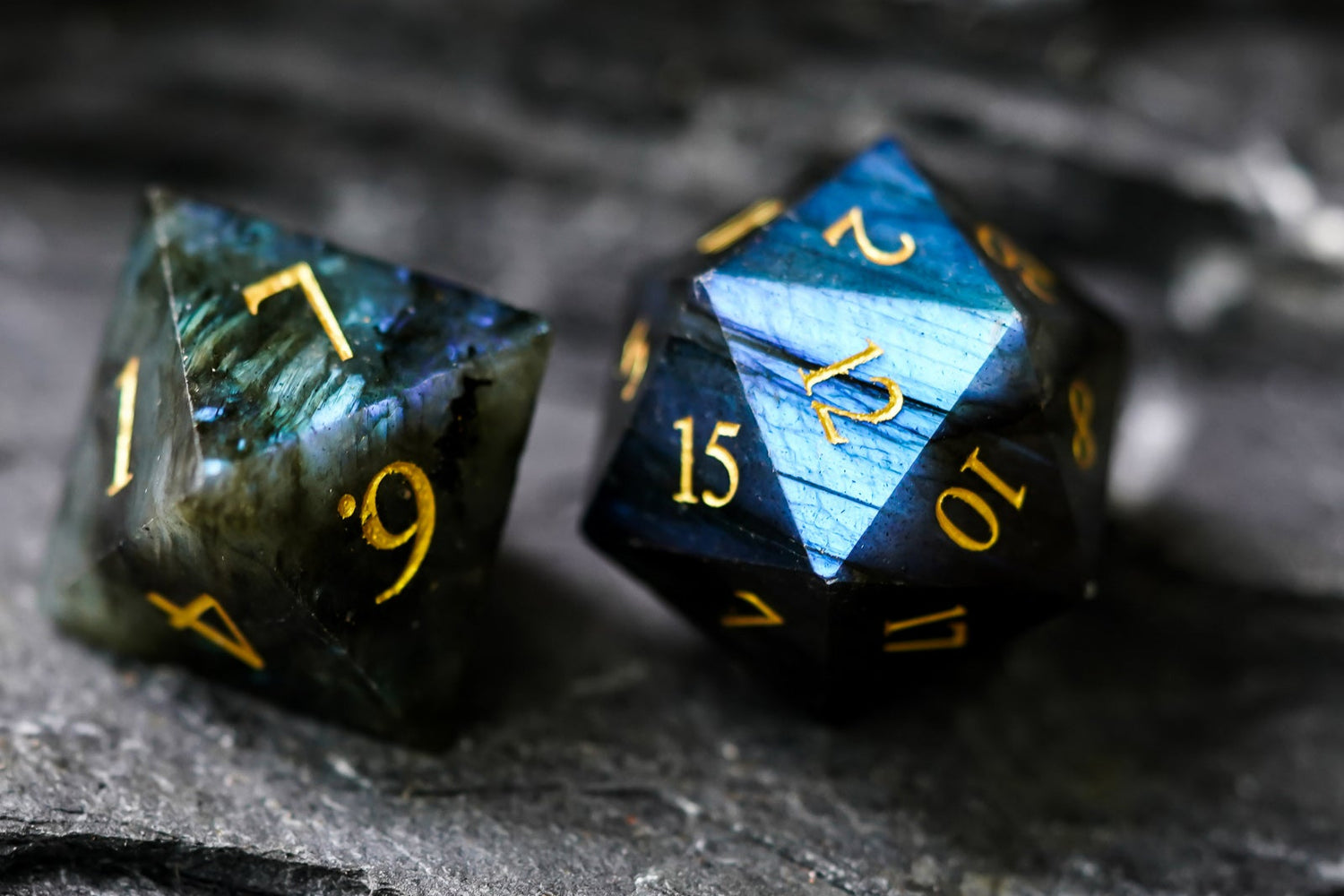 Pair of labradorite gemstone D20 dice with shimmering blue and gold accents, ideal for DND and tabletop RPGs.