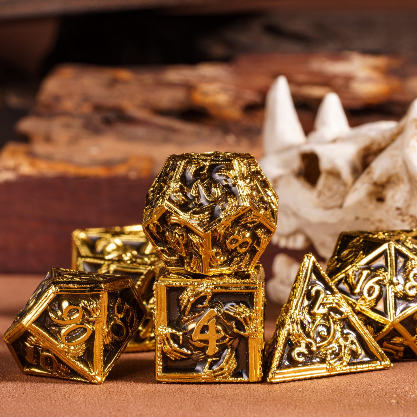 Onyx Crypt Metal Dice Set black & gold polyhedral dice displayed with skull prop