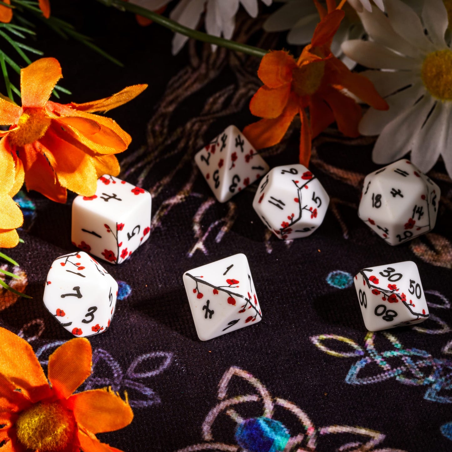 Tabletop display of Plum Blossom Dice Set surrounded by flowers for DnD & DnD 5e