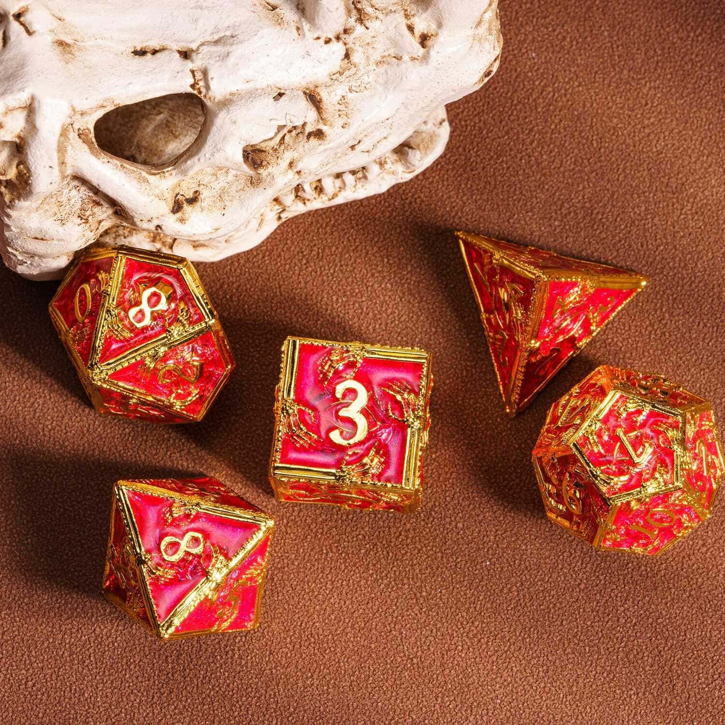 Royal Crypt Metal Dice Set scattered red & gold RPG dice with skull background