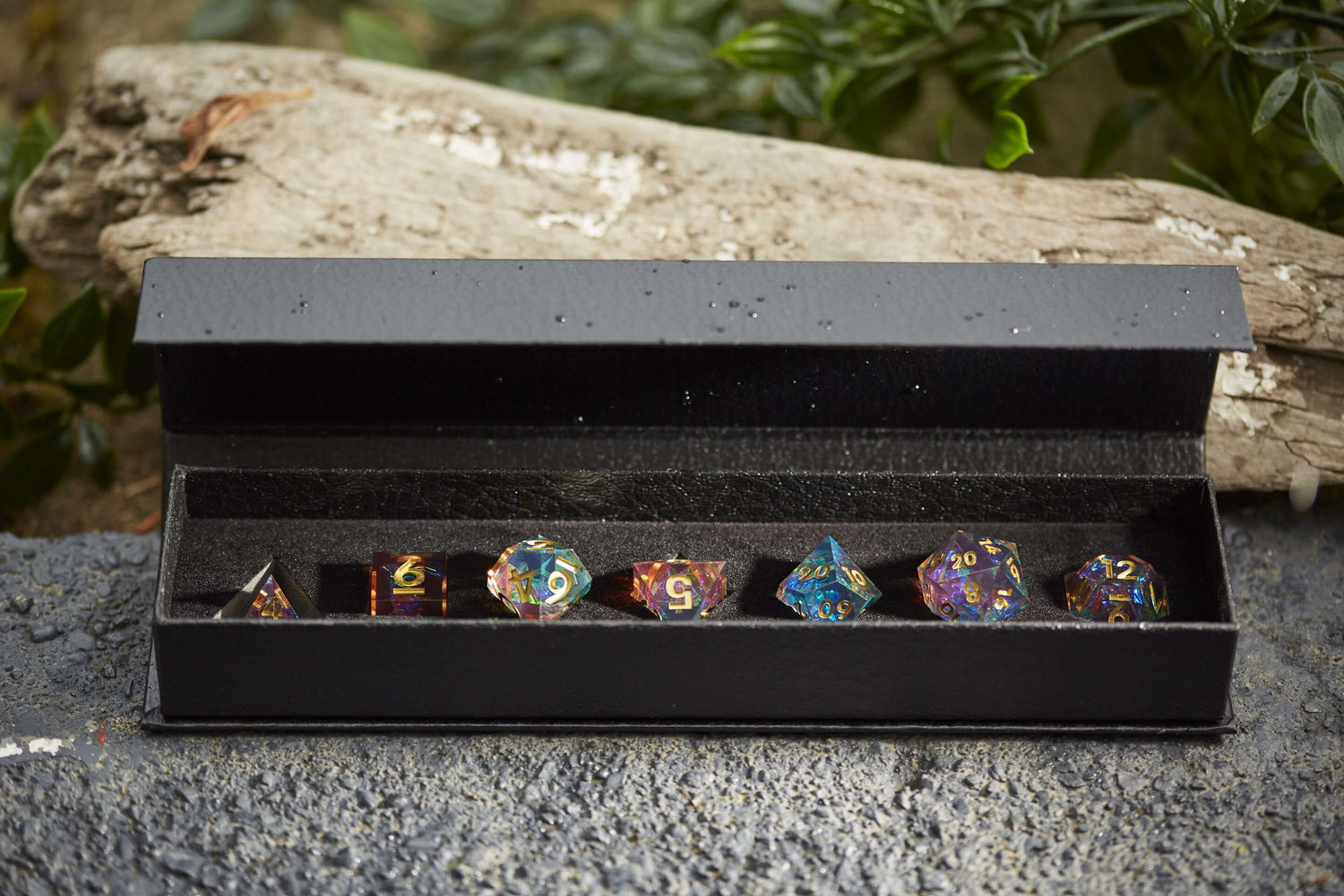 Starlight Nebula sharp-edge resin dice set with vibrant rainbow reflections, shown in a black presentation case for tabletop RPGs like DND.