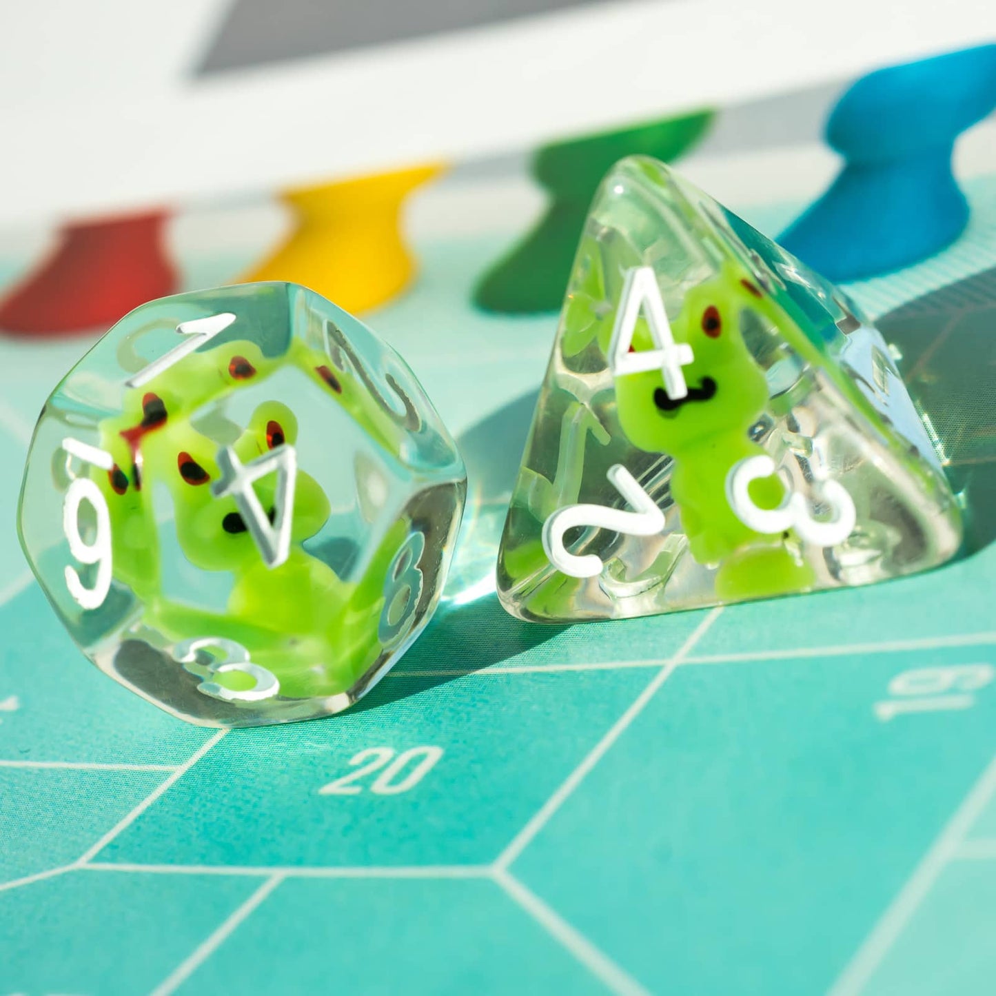 Transparent Froggo Dice Set on colorful board game surface with vibrant lighting