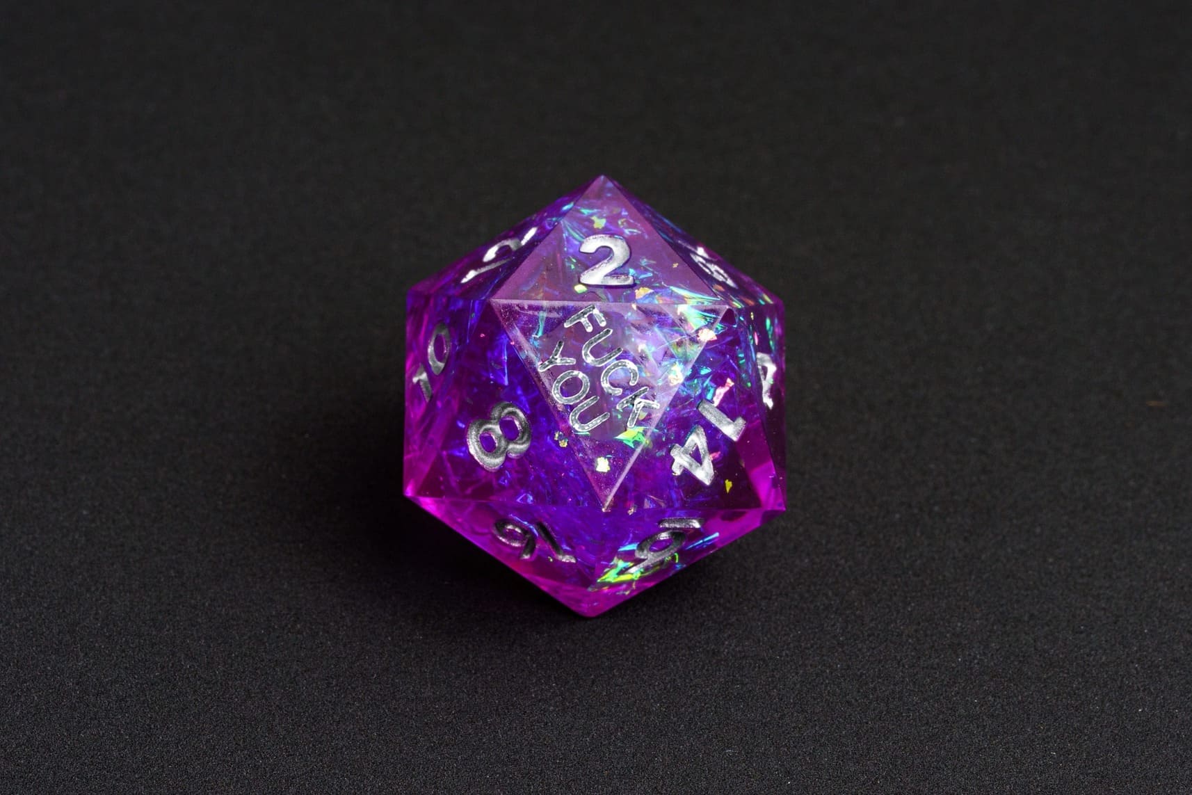 Violet Beam sharp-edge D20 from the Fck Me Dice Set, purple resin with silver numbering and 'Fck You' lettering