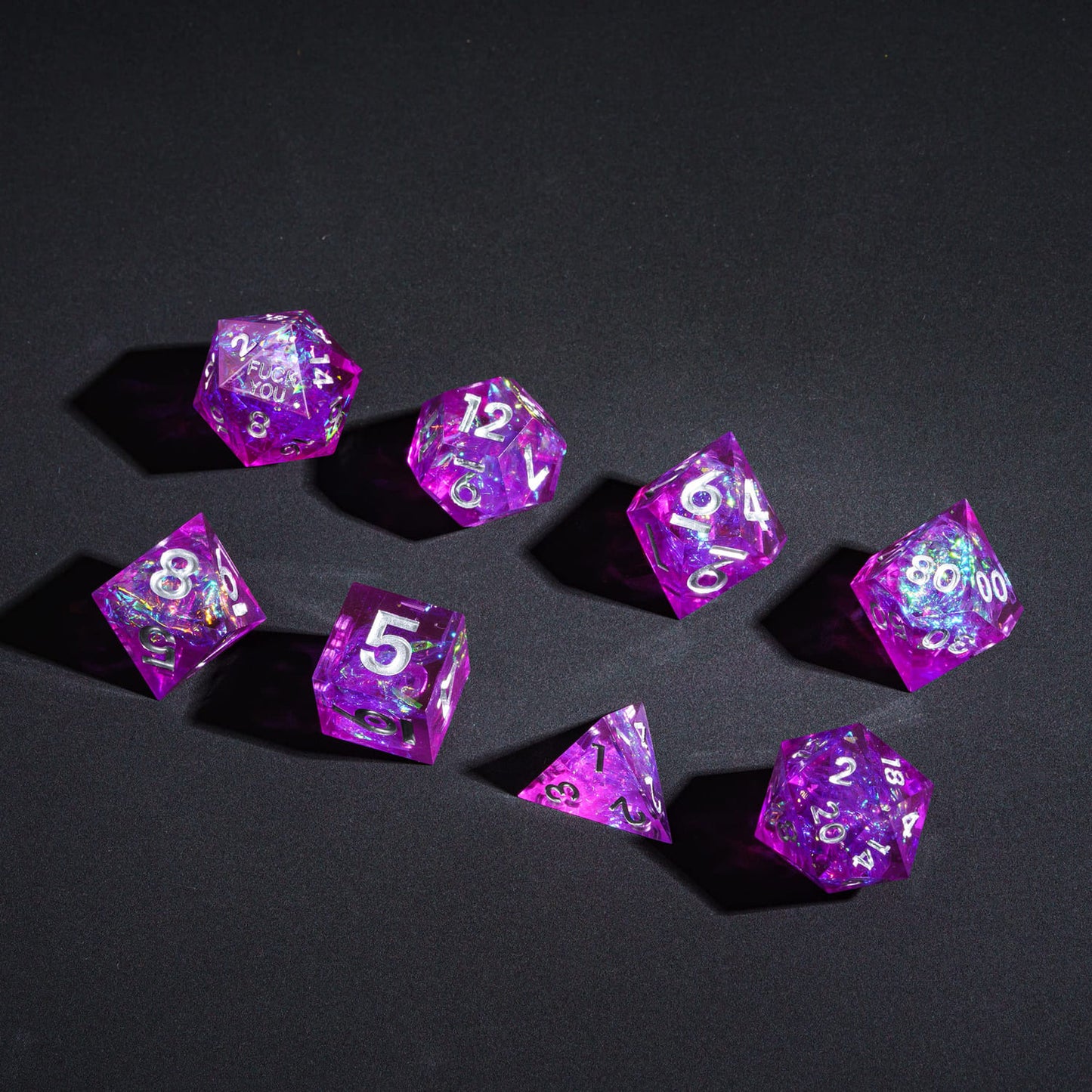 Flat lay of Violet Beam F*ck Me Sharp Edge 7 Piece Dice Set for DnD 5e