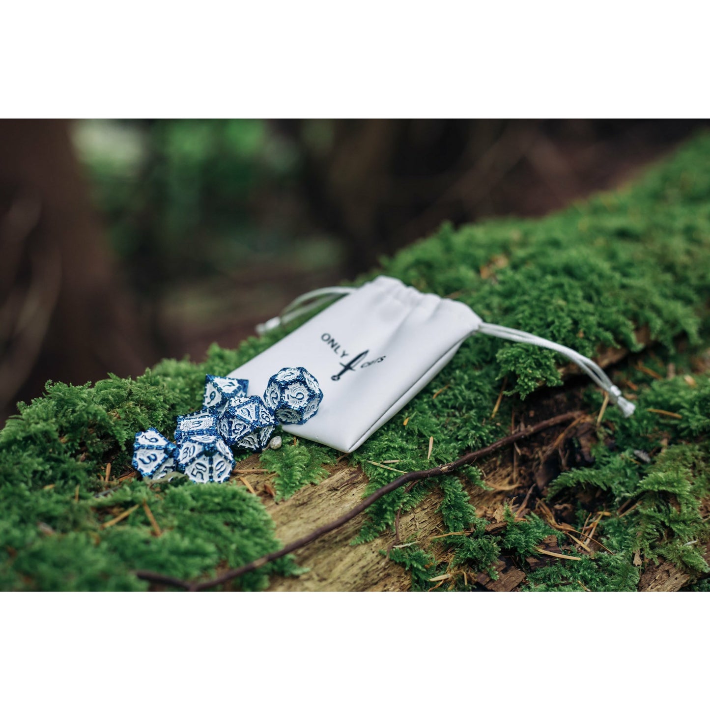 Icy Blade metal dagger dice set for DnD & TTRPG, in bag on forest log