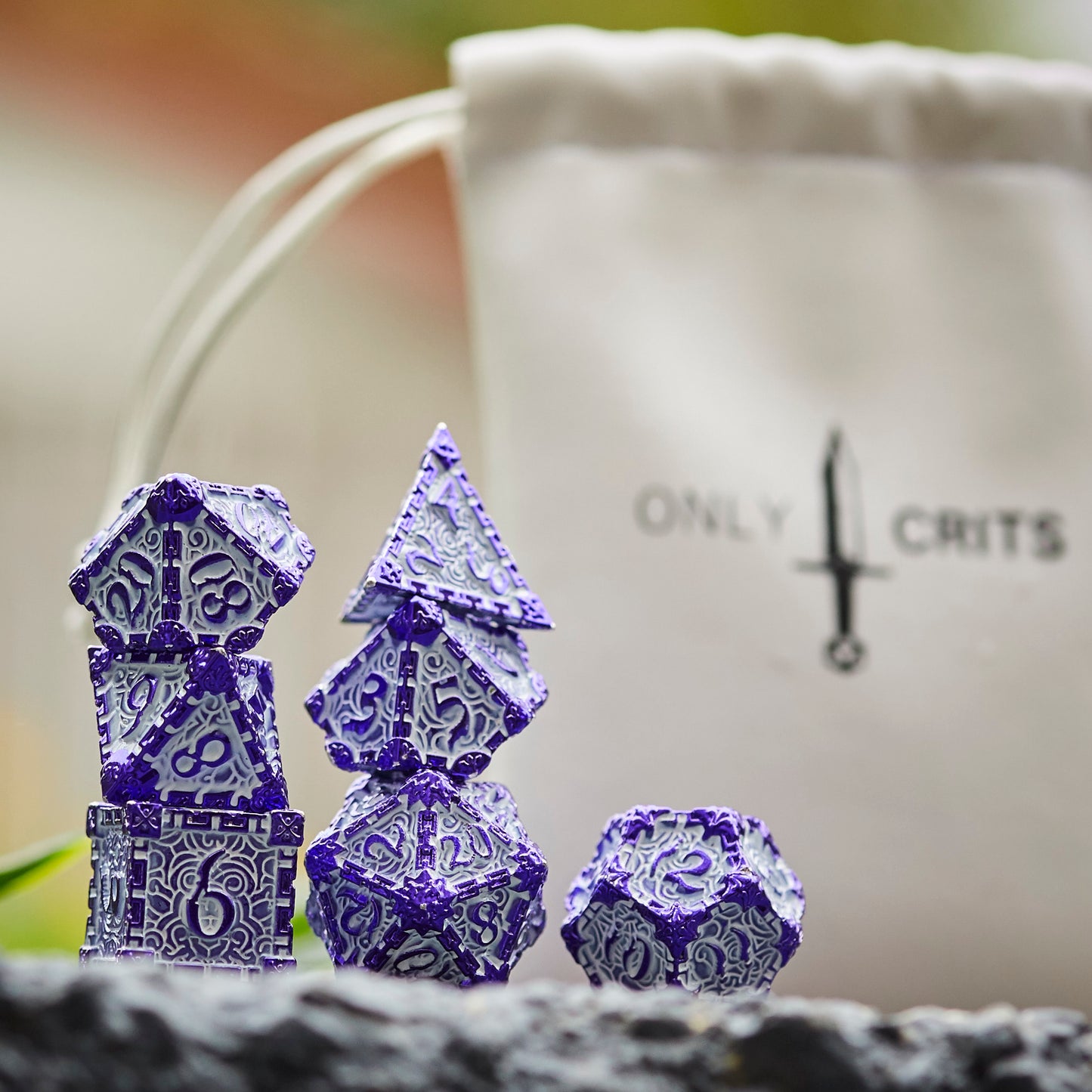 Lavender Blade metal dagger dice set for DnD & TTRPG, displayed with bag outdoors