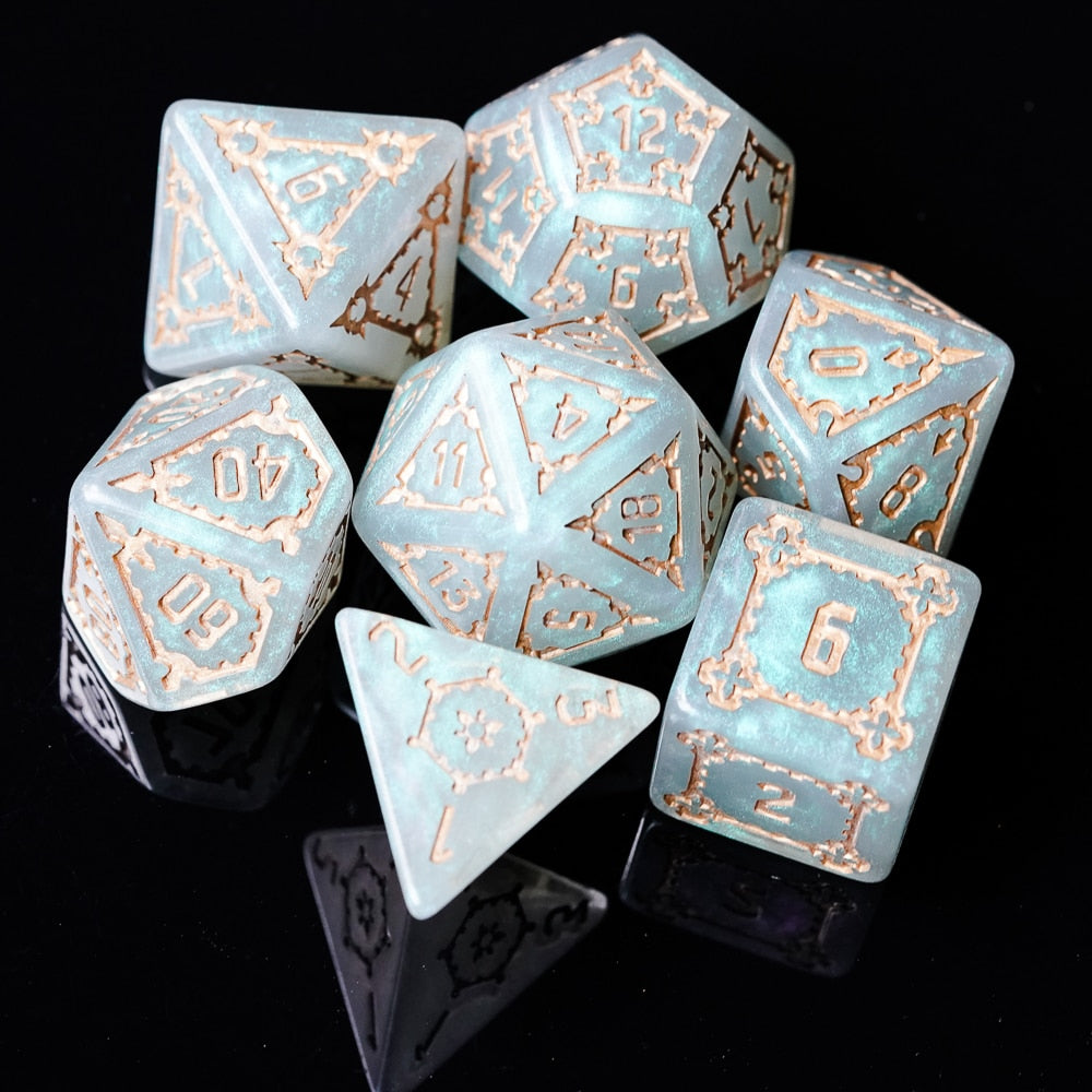 Moonlight Elixir huge 7-piece dice set laid out with glowing blue pearl resin and engraved bronze-style numbering