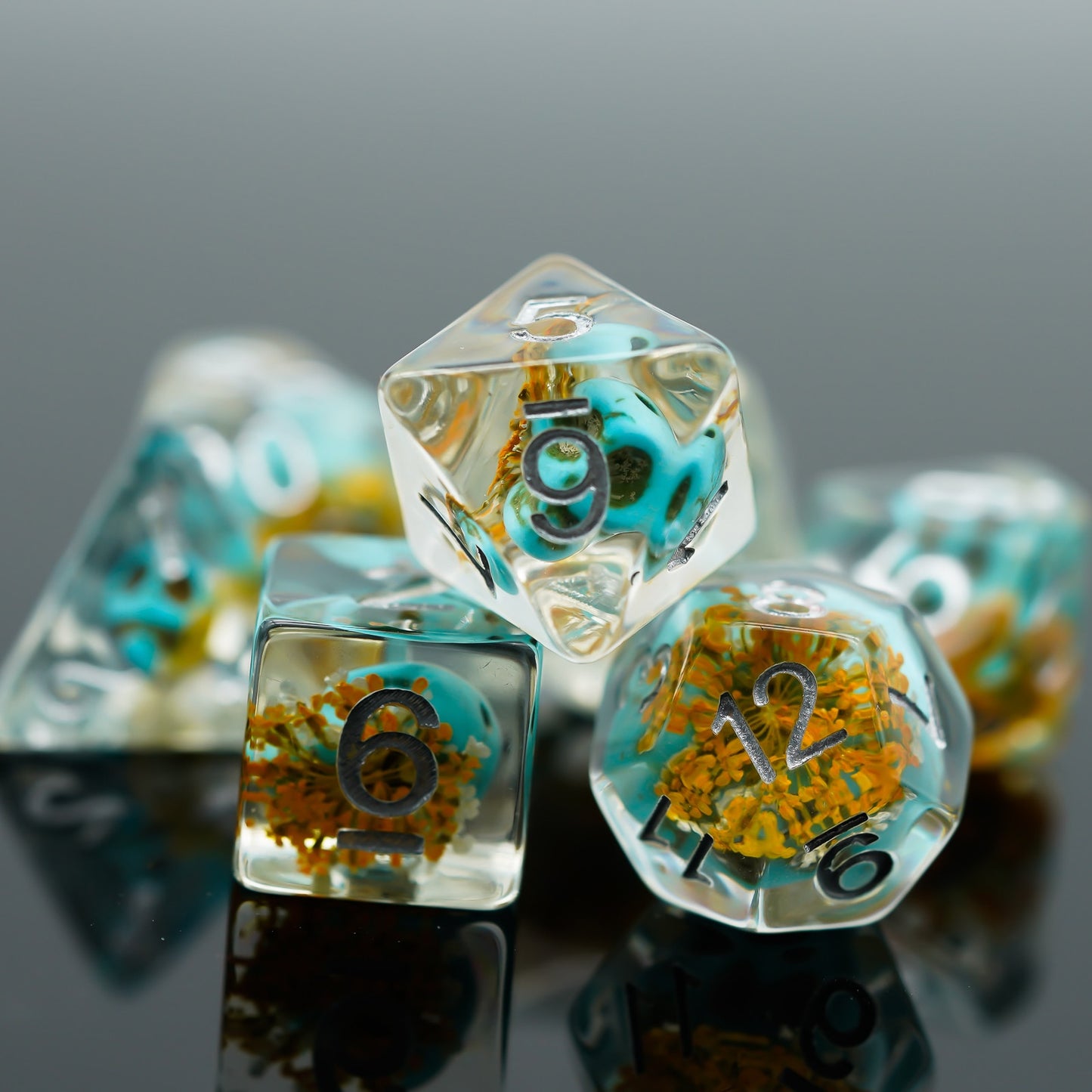 Close-up view of Ocean Wizards Phylactery dice with embedded blue skulls and yellow florals in resin