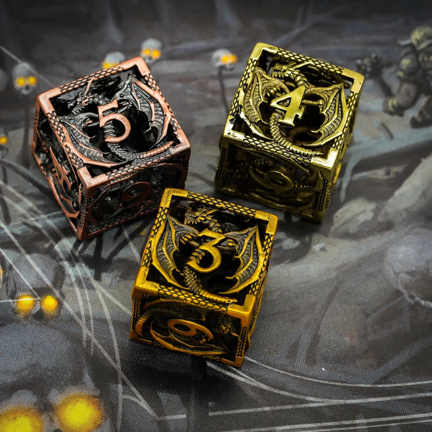 Three different colors of the hollow metal dragon dice sets on dark forest background