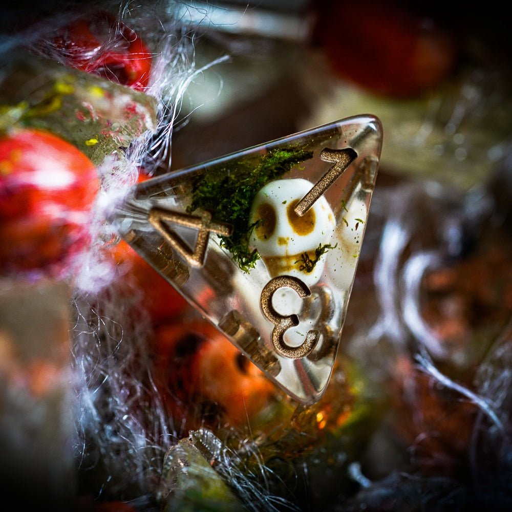 Detailed view of D4 from Wizards Phylactery dice set with skull and moss inside