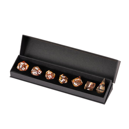 Aether Shards Sharp Edge Dice Set displayed in a premium black magnetic gift box with seven translucent amber resin dice