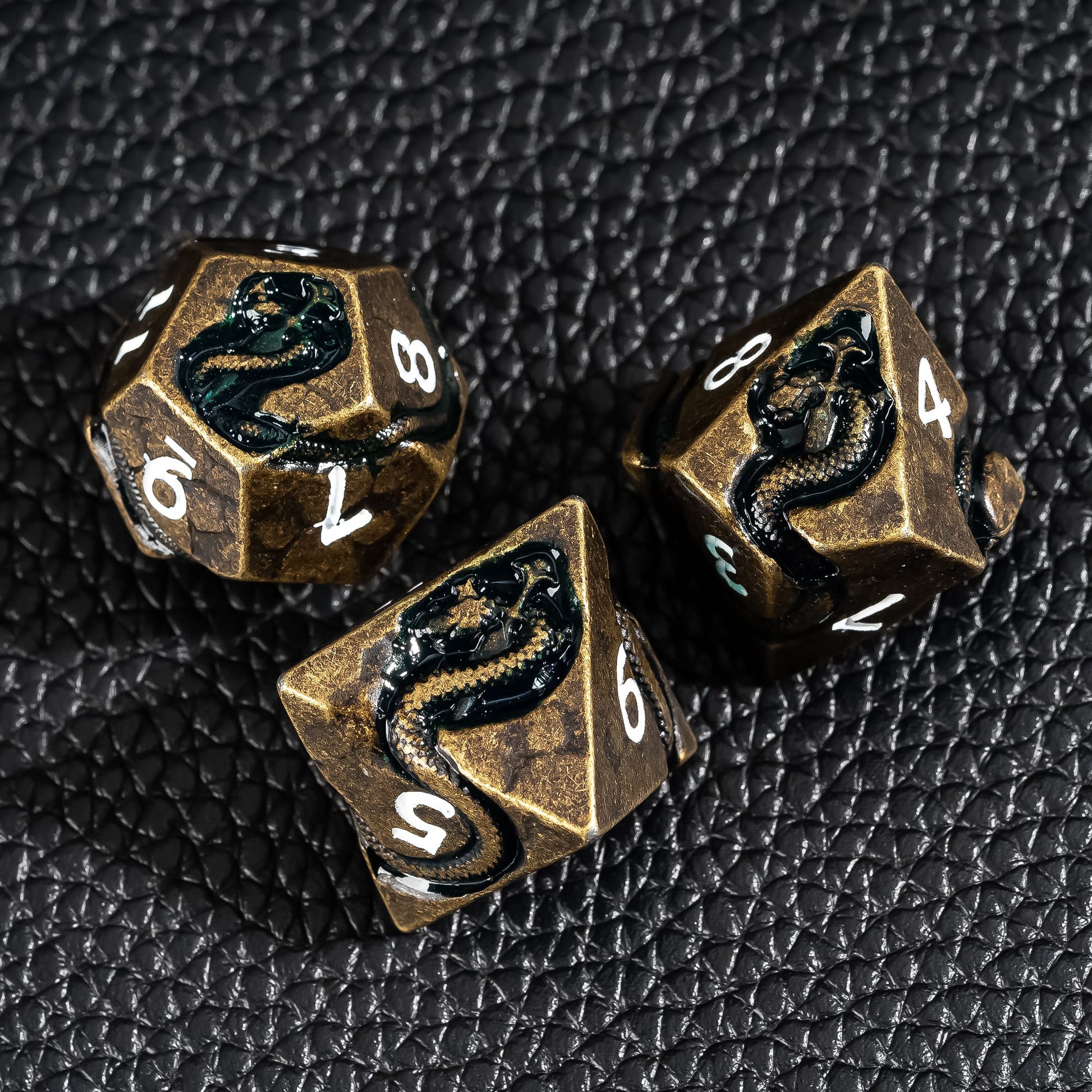 Close up of Ancient Bronze Serpent metal dice showing detailed serpent engravings