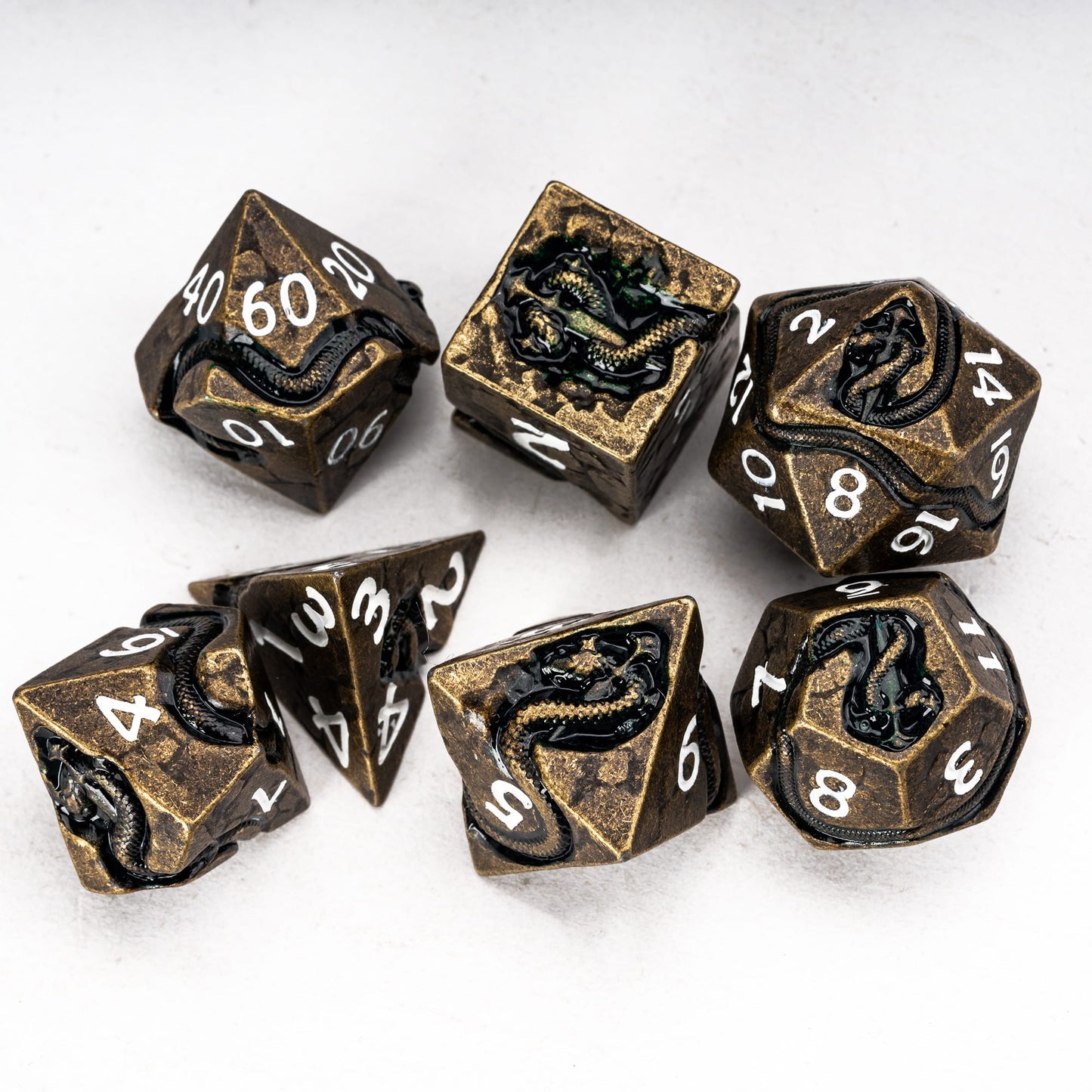 Ancient Bronze Serpent 7 piece metal dice set flat lay with engraved serpent details for DnD