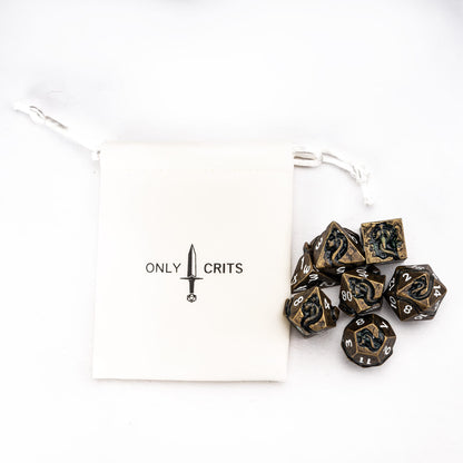 Ancient Bronze Serpent metal dice set with branded dice pouch flat lay for DnD and tabletop RPGs