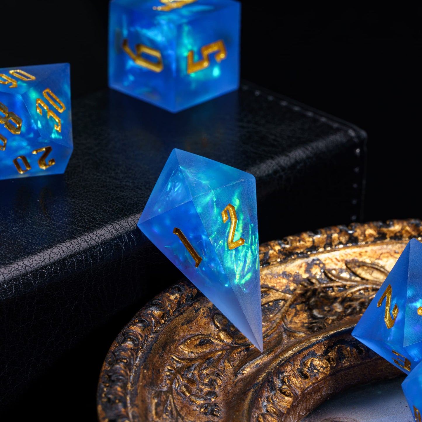 Azure Abyss D4 sharp edge die in blue resin with gold numbering and teal shimmer