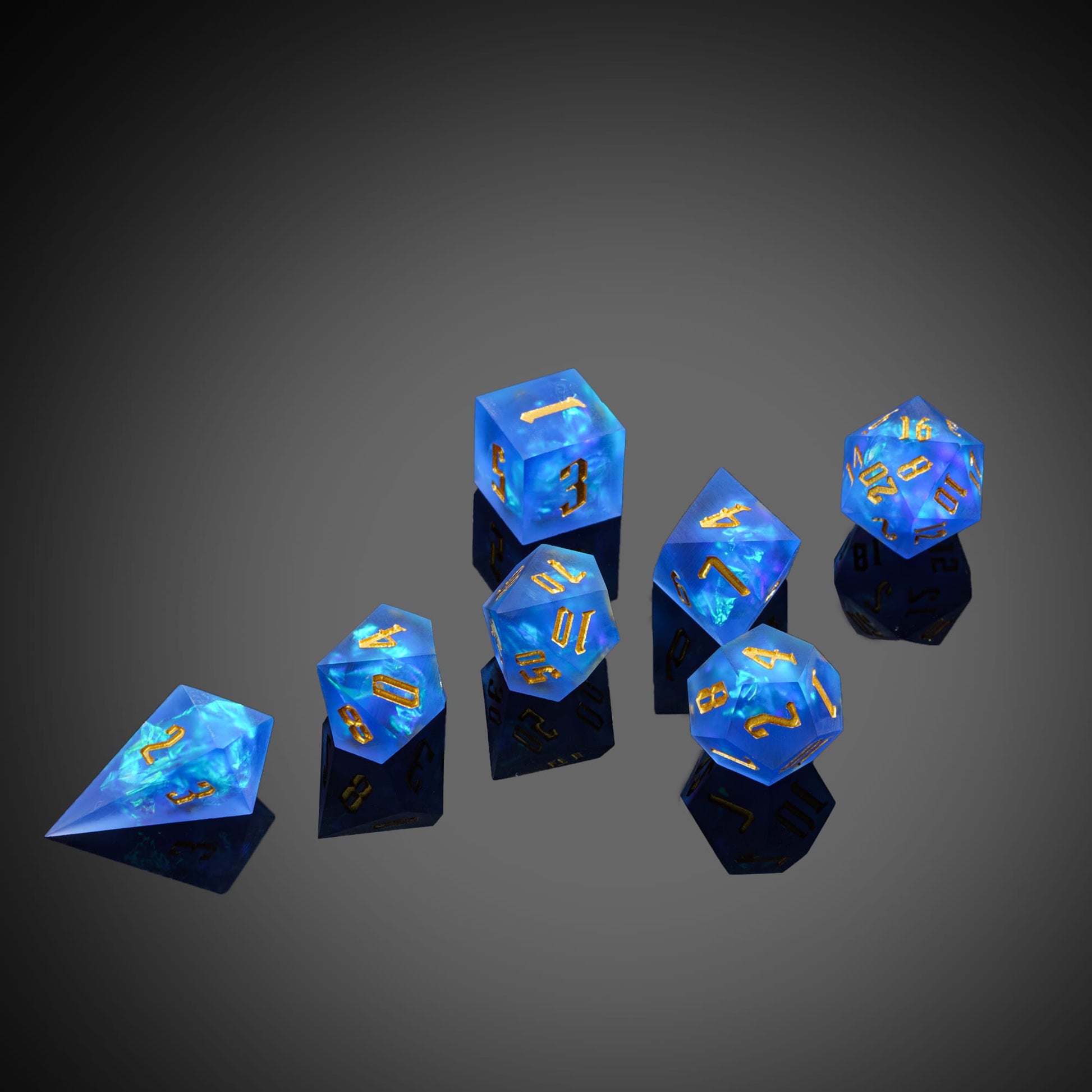 Azure Abyss sharp edge dice set in deep blue resin with gold numbers on dark reflective surface