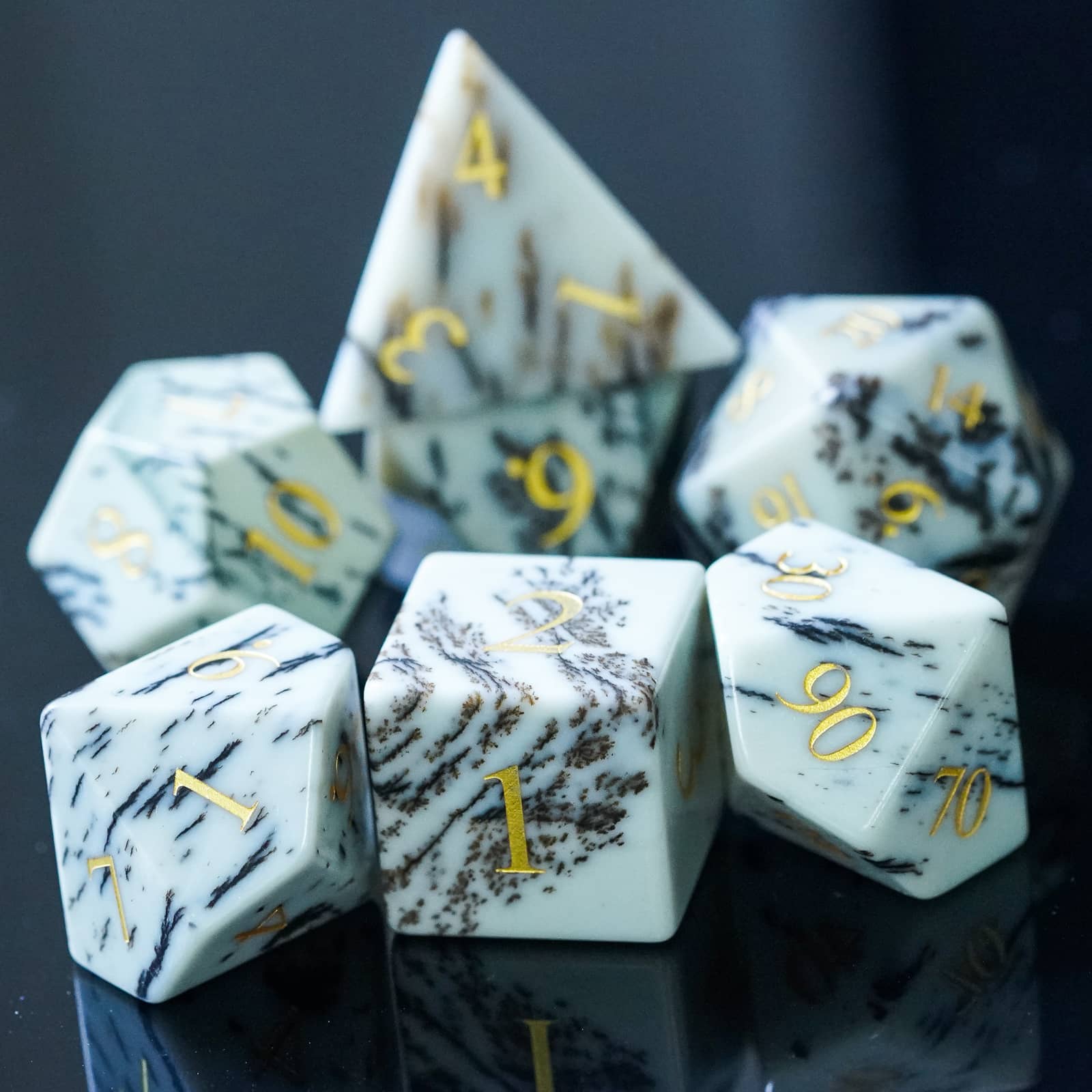 Birch Stonework Stone Dice Set grouped together on glossy black surface for DnD players