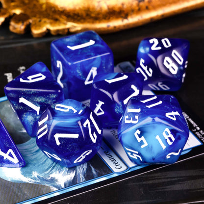 Blue Sapphire polyhedral dice set with shimmering blue resin and white numbers angled view