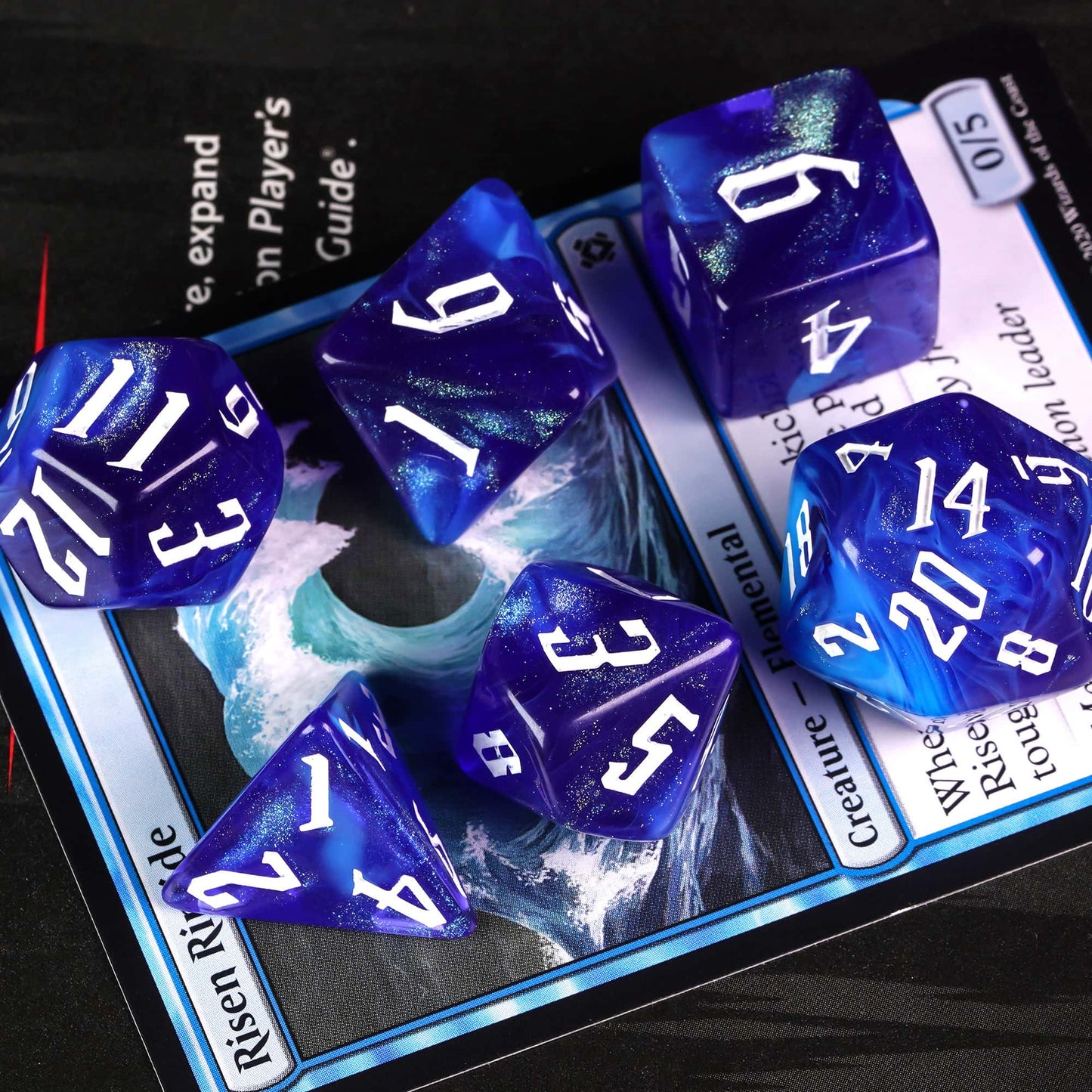 Blue Sapphire sharp edge polyhedral dice set with white numbers closeup on card