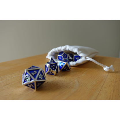 Blue & silver Bob World Builder dice spilling out of white drawstring bag on wooden table