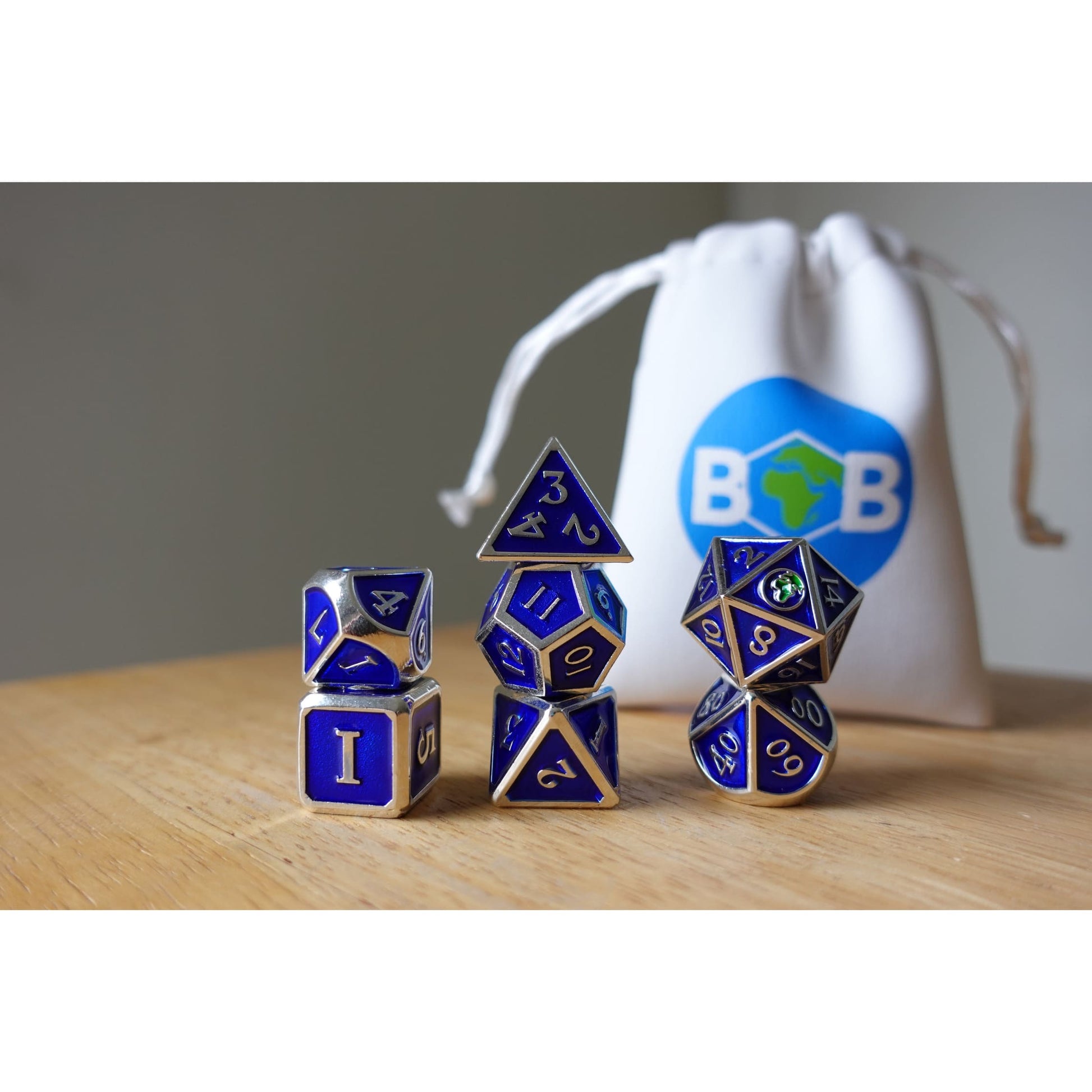 Blue & silver Bob World Builder dice stacked in front of white dice bag