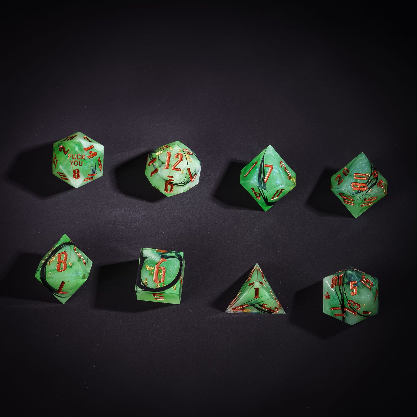 Flat lay of Bog Hag Sharp Edge Dice Set with green resin swirl design