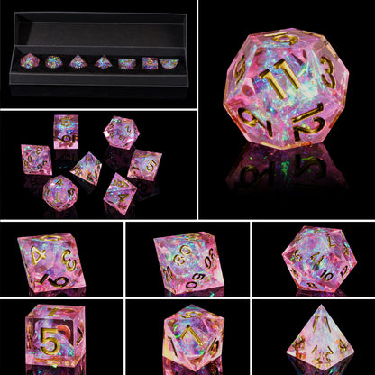 Close up of Celestial Heart sharp edge dice showing pink resin, iridescent flakes, and gold numbering