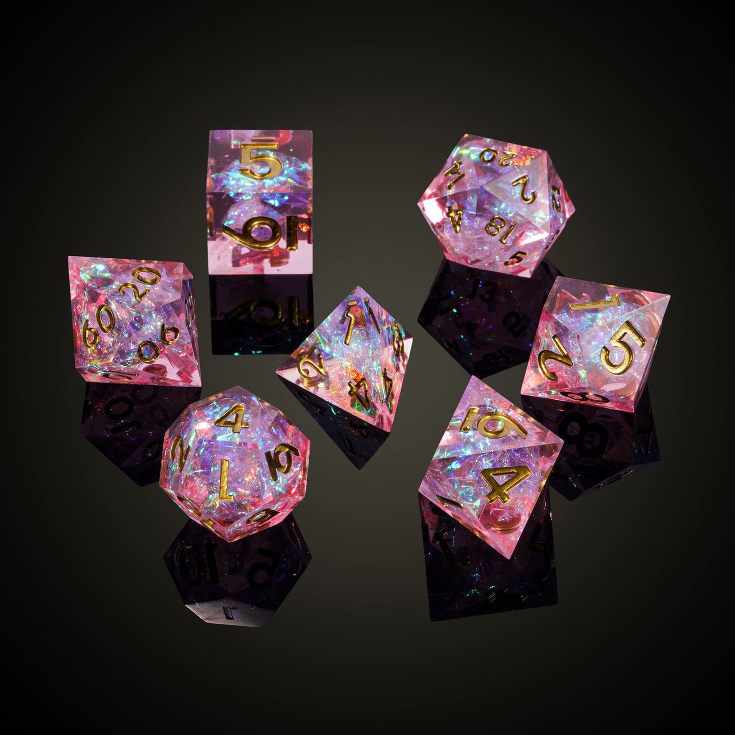 Celestial Heart sharp edge dice set arranged on black background, pink resin dice with gold numbers