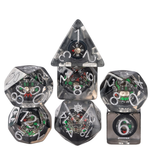 Stacked Compass Core dice set featuring miniature compass inclusions suspended in smoky clear resin with silver numbering