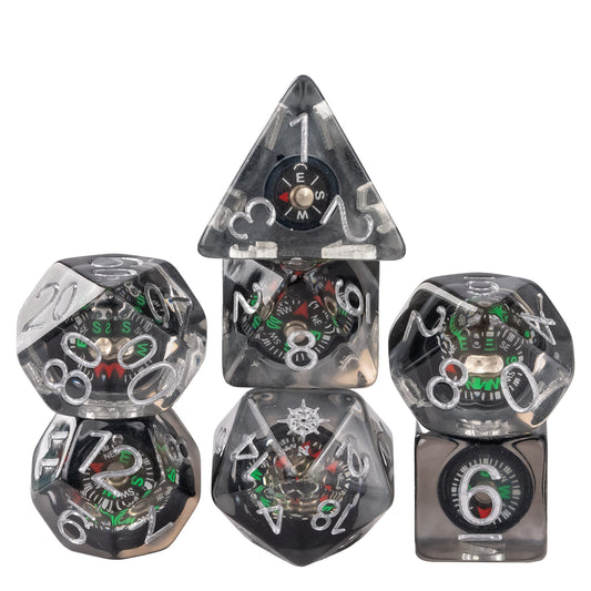 Stacked Compass Core dice set featuring miniature compass inclusions suspended in smoky clear resin with silver numbering