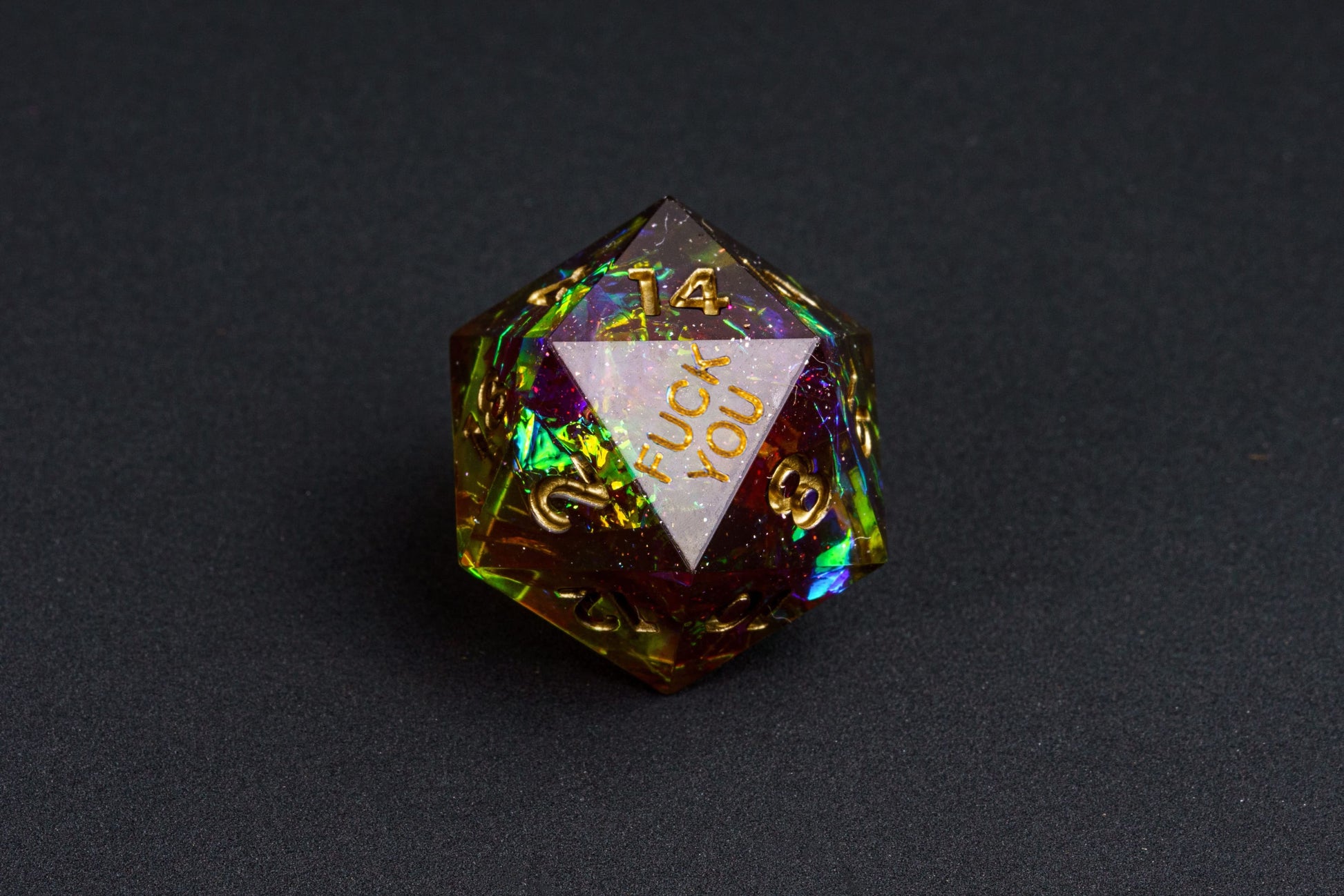 Close-up of the Corrupted Meadow F*ck Me sharp edge D20 with gold numbers and holographic shimmer