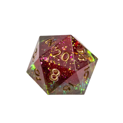 Close up of Corrupted Meadow sharp edge D20 resin dice with red, green and gold foil flakes and gold inked numbers for DnD