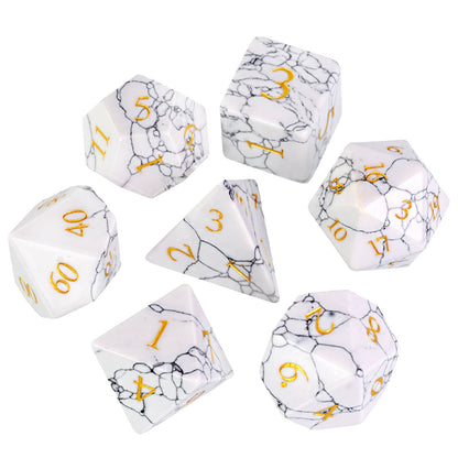 Flat lay of Cracked Marble Stone Dice Set showing seven dice with black veining and gold numbers