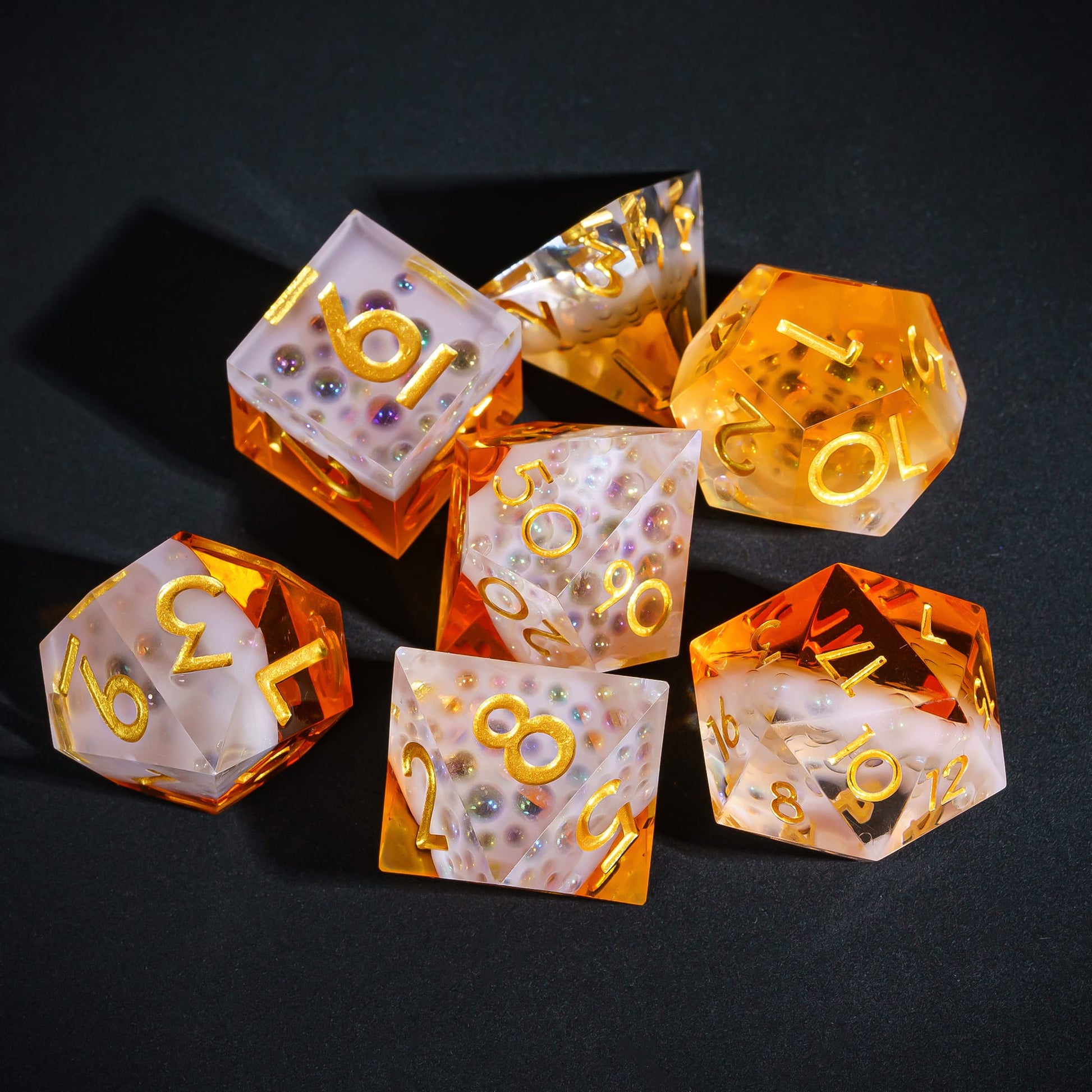 Crisp Brew Sharp Edge Dice Set grouped on black surface showing frosted resin and amber tones