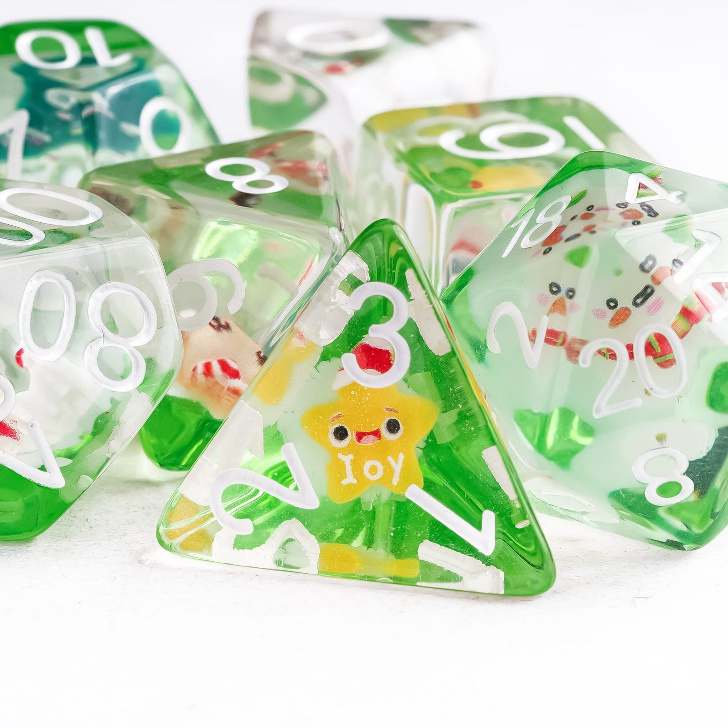 Close up of Critmas Crew holiday D4 resin die with green and white design for DnD and tabletop RPG players