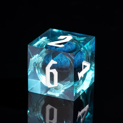 Close up of Dragon Eye Blue D6 sharp edge resin dice with floating blue core and white numbers