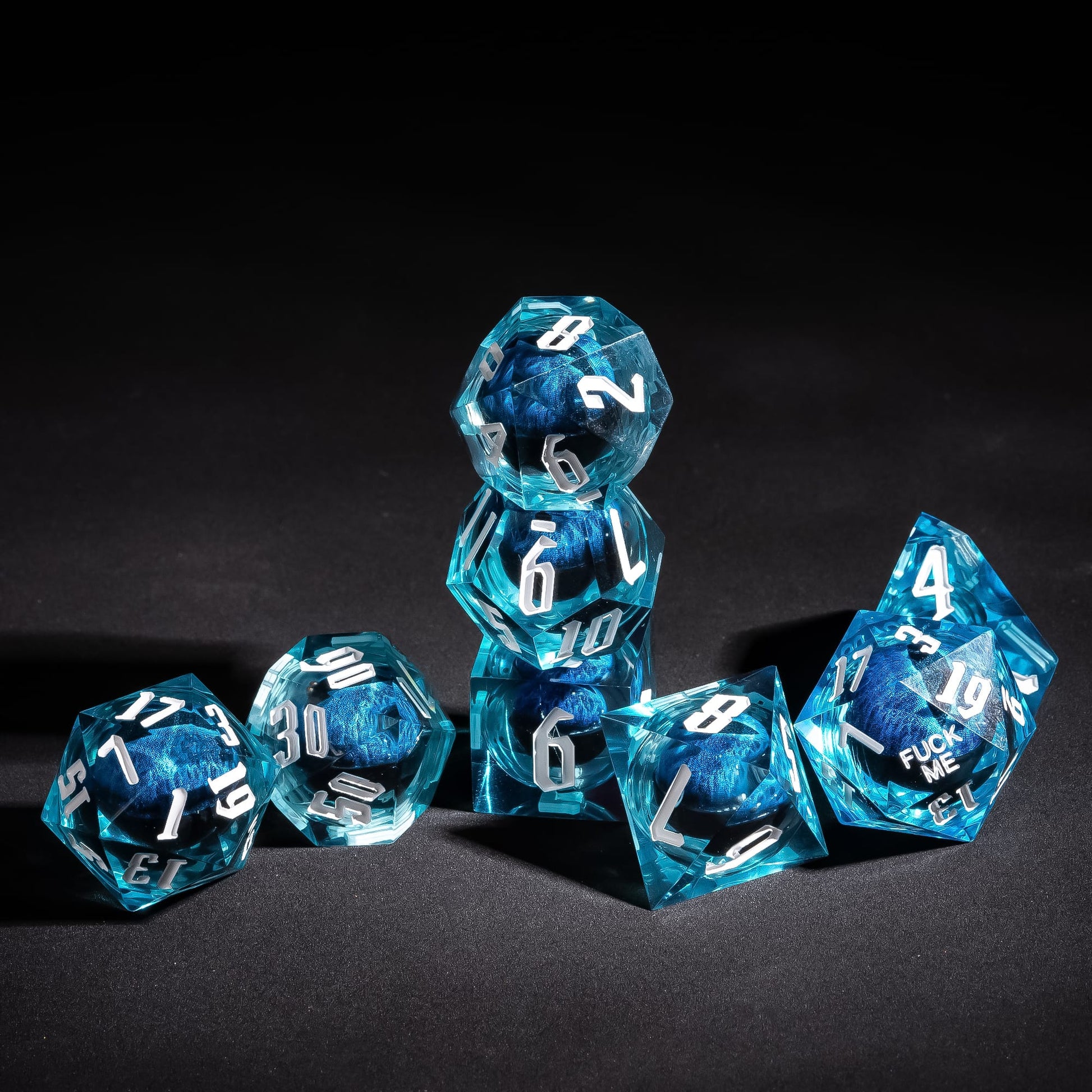 Stacked display of Dragon Eye Blue Fuck Me Sharp Edge Dice Set for DnD & tabletop RPGs